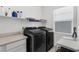 Well-equipped laundry room featuring sleek, front-loading washer and dryer, and laminate countertops at 2935 Gaffer Film St, Las Vegas, NV 89156