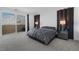 This spacious main bedroom features sliding glass doors to a balcony, bedside tables and bedside lamps at 2935 Gaffer Film St, Las Vegas, NV 89156