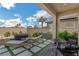Relaxing patio with lounge chairs, an outdoor table set, a jacuzzi, and a view of a neatly landscaped yard at 2935 Gaffer Film St, Las Vegas, NV 89156
