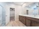 Bright bathroom featuring double sink vanity, wood-look flooring, and a glass-enclosed shower at 4294 Eagle Summit Ave, Las Vegas, NV 89141