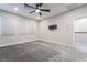 Bright bedroom featuring gray carpet, a modern ceiling fan, ample natural light, and a wall-mounted TV bracket at 4294 Eagle Summit Ave, Las Vegas, NV 89141