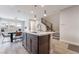 Open concept kitchen features a central island with sink, dining area, and staircase, all illuminated by modern pendant lighting at 4294 Eagle Summit Ave, Las Vegas, NV 89141