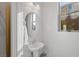 Bright powder room features a round mirror and a pedestal sink with natural light at 436 Trevinca St, Las Vegas, NV 89138