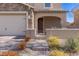 Home exterior featuring a stone accented two car garage, arched porch and desert landscaping for great curb appeal at 436 Trevinca St, Las Vegas, NV 89138