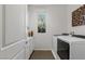 Well-lit laundry room with modern washer and dryer, cabinets and decorative vases at 436 Trevinca St, Las Vegas, NV 89138