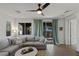Bright living room with a plush sofa, modern ceiling fan, and sliding door access at 436 Trevinca St, Las Vegas, NV 89138