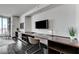 Contemporary home office featuring built-in shelving, a large screen television, and city views at 4381 W Flamingo Rd # 3206, Las Vegas, NV 89103