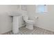 Bright half bathroom features pedestal sink, toilet, and window with blind, on decorative tile flooring at 4526 Cloudrest Peak St, North Las Vegas, NV 89031
