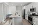 Chic kitchen features stainless appliances, granite counters, island with seating, and bright, airy design at 4526 Cloudrest Peak St, North Las Vegas, NV 89031