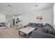 Open-concept living area with modern light fixtures, wood flooring, a kitchen, and a comfortable gray sofa at 4526 Cloudrest Peak St, North Las Vegas, NV 89031