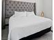 Comfortable bedroom features a tufted headboard and crisp white bedding, creating a serene and inviting sleeping space at 4526 Cloudrest Peak St, North Las Vegas, NV 89031