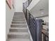 Carpeted staircase with dark wood railing, blending functionality with modern design, and leading to the upper levels of the home at 4526 Cloudrest Peak St, North Las Vegas, NV 89031