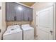 Functional laundry room with modern washer and dryer units and gray cabinetry at 474 Adelle Ave, Overton, NV 89040