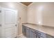 Laundry room with gray cabinets, granite countertops, neutral walls and white door at 474 Adelle Ave, Overton, NV 89040