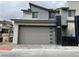 Contemporary two-story home featuring a modern gray facade, a two-car garage, and sleek architectural details at 483 Fairview Hills St, Las Vegas, NV 89138