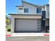Modern two-car garage with gray door and brick-paved driveway on a sunny day at 483 Fairview Hills St, Las Vegas, NV 89138
