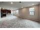 Bright, carpeted living room with a modern kitchen in the background, perfect for entertaining at 483 Fairview Hills St, Las Vegas, NV 89138