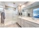 Modern bathroom features double sinks, a glass shower, and neutral tile flooring at 49 Alamere Falls Dr, Las Vegas, NV 89138