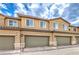 Charming townhouse with multiple windows, large garage doors, and well-kept front yard at 49 Alamere Falls Dr, Las Vegas, NV 89138