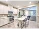Bright kitchen features white cabinets, stainless steel appliances, and a center island with seating at 49 Alamere Falls Dr, Las Vegas, NV 89138