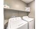 Bright laundry room with washer and dryer, plus overhead shelf space for storage at 49 Alamere Falls Dr, Las Vegas, NV 89138