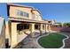 Exterior view of the two-story home featuring a covered patio and landscaped backyard at 4937 Teal Petals St, North Las Vegas, NV 89081