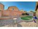 Low maintenance backyard featuring gravel landscaping, a small patch of artificial turf, and block wall fencing at 4937 Teal Petals St, North Las Vegas, NV 89081