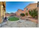 Backyard features a charming artificial turf area surrounded by decorative rock and block wall at 4937 Teal Petals St, North Las Vegas, NV 89081