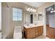 Bright bathroom showcasing a double sink vanity, tiled shower-tub, and natural light at 4937 Teal Petals St, North Las Vegas, NV 89081