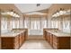 Bathroom with double sinks, large mirrors, and a soaking tub under a window at 4937 Teal Petals St, North Las Vegas, NV 89081
