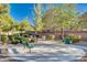 Park view featuring mature landscaping, benches, and shaded barbecue area with concrete pad for outdoor gatherings at 4937 Teal Petals St, North Las Vegas, NV 89081