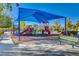 Community playground featuring slides, climbing structures, and a large shade canopy for to play on at 4937 Teal Petals St, North Las Vegas, NV 89081