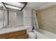 Bathroom with granite counters, a wooden vanity and shower-tub combination with tile backsplash at 4998 Schumann Dr, Las Vegas, NV 89146
