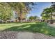 View of a well-maintained common area with lush green grass, mature trees, and seating at 4998 Schumann Dr, Las Vegas, NV 89146