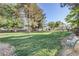 Lush green common area with mature trees, a bench, and a walkway at 4998 Schumann Dr, Las Vegas, NV 89146