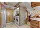 Tiled laundry room with wooden door, stainless fridge, and laundry machines at 4998 Schumann Dr, Las Vegas, NV 89146