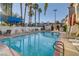 Beautiful swimming pool area with lounge chairs, palm trees, and clear blue water at 4998 Schumann Dr, Las Vegas, NV 89146