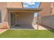 The backyard features a covered patio, block wall fencing, and easy-care artificial turf at 5001 Volcanic Rock Ln, Las Vegas, NV 89122
