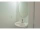 Small bathroom with a round mirror and bright overhead lighting at 5001 Volcanic Rock Ln, Las Vegas, NV 89122
