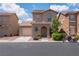 Two-story home featuring a garage, low-maintenance desert landscaping, and a red motorcycle at 5001 Volcanic Rock Ln, Las Vegas, NV 89122