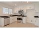 Modern kitchen with stainless steel appliances, white cabinets, and black countertops at 5001 Volcanic Rock Ln, Las Vegas, NV 89122