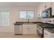 Kitchen showcasing stainless steel appliances, dark countertops, and bright natural light at 5001 Volcanic Rock Ln, Las Vegas, NV 89122