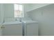 Practical laundry area with full-size white washer and dryer and plenty of light at 5001 Volcanic Rock Ln, Las Vegas, NV 89122