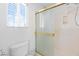 Bathroom with glass-enclosed shower, toilet, and window letting in plenty of natural light at 5396 Valley Wells Way, Las Vegas, NV 89113