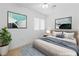 Staged bedroom with a comfortable bed, artwork, and a view of the outdoors through the window at 5396 Valley Wells Way, Las Vegas, NV 89113