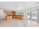 Open kitchen area with tile floors, natural wood cabinets, and sliding glass doors to the backyard patio at 5396 Valley Wells Way, Las Vegas, NV 89113