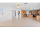 Bright, open-concept living room and kitchen with tile flooring and natural wood cabinets at 5396 Valley Wells Way, Las Vegas, NV 89113
