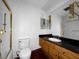 Outdated bathroom features a shower-tub combo with gold trim, wood vanity and dark floors at 540 Tam O Shanter, Las Vegas, NV 89109