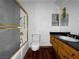 Outdated bathroom features a shower-tub combo with gold trim, wood vanity and dark floors at 540 Tam O Shanter, Las Vegas, NV 89109
