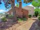Brick exterior with a well-manicured lawn, a brick chimney, and mature, lush landscaping at 540 Tam O Shanter, Las Vegas, NV 89109